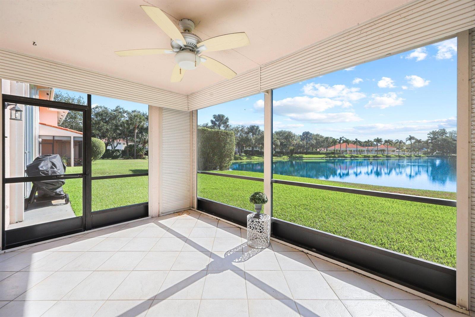 A grassy lawn leads to a calm lake surrounded by trees and residential buildings — 8634 Via Reale # 3, Boca Raton FL 33496, BOCA RATON, FL