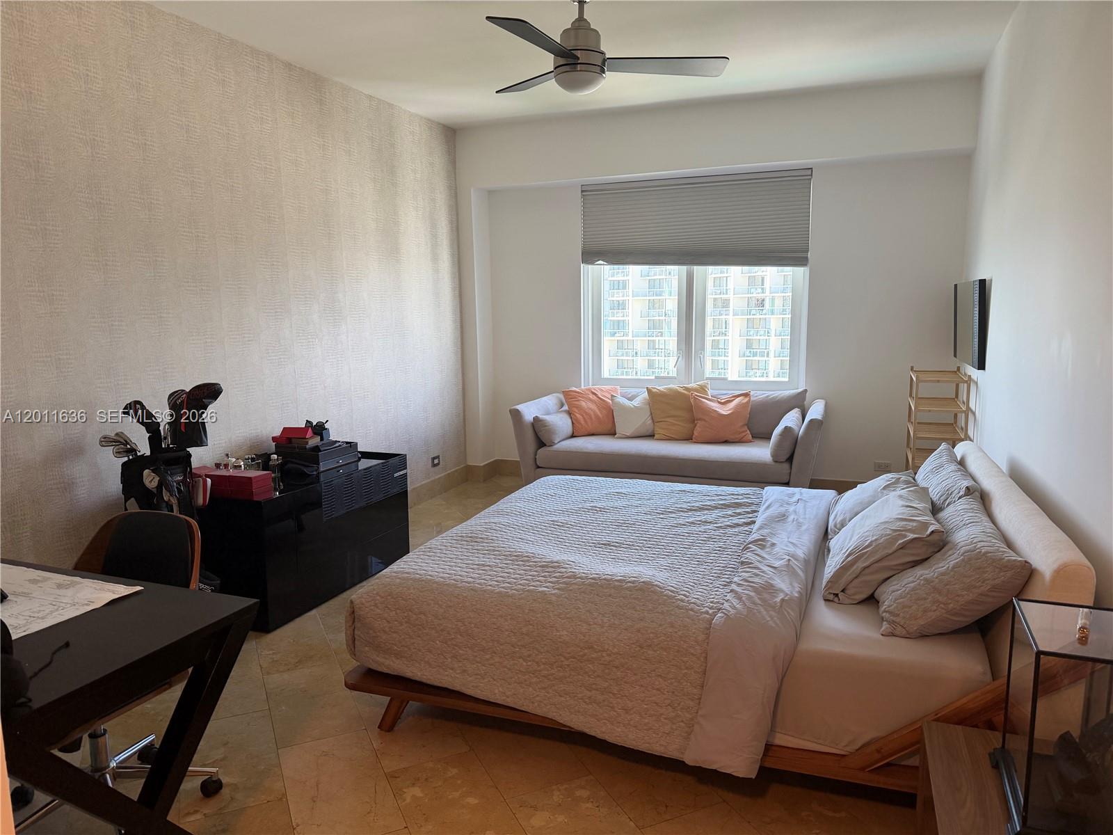 A bedroom features a bed, a small sofa by the window, and a desk area — 2301 Collins Ave, Miami Beach FL 33139, MIAMI BEACH, FL