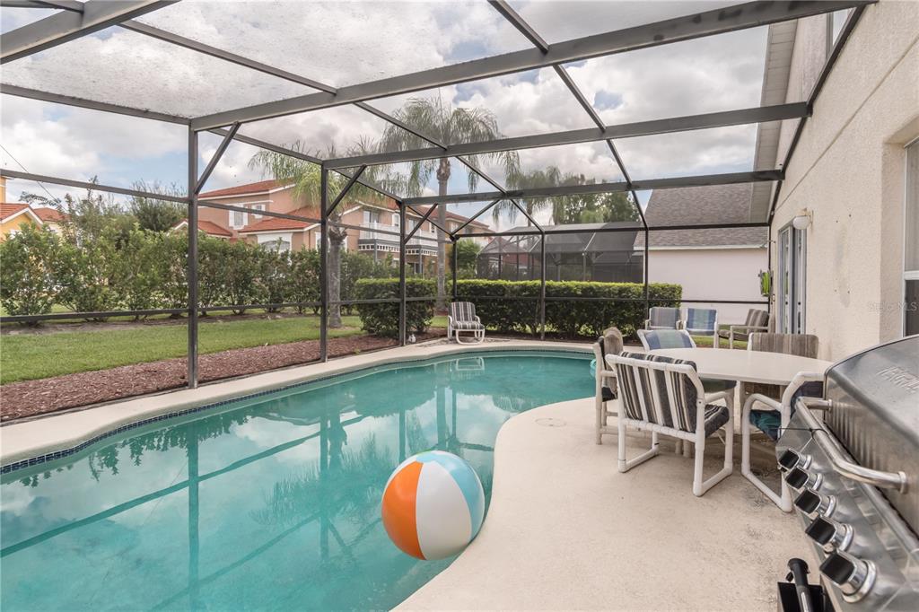 A screened-in patio features a swimming pool, outdoor furniture, and a grill — 4609 FORMBY COURT, KISSIMMEE, FL