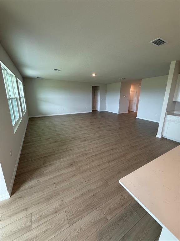 An open-concept living area features light wood-look flooring, neutral walls, and recessed lighting — 11003 44TH AVENUE E, PALMETTO, FL