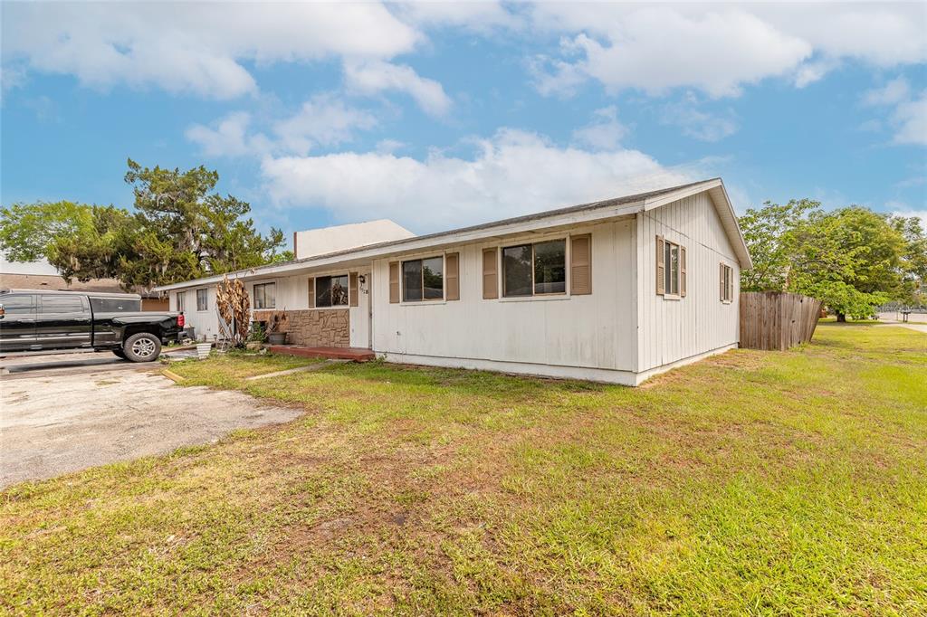 A single-story house with white vertical siding, a stone accent wall, and a concrete driveway — 632 LPGA BOULEVARD UNIT B, DAYTONA BEACH, FL