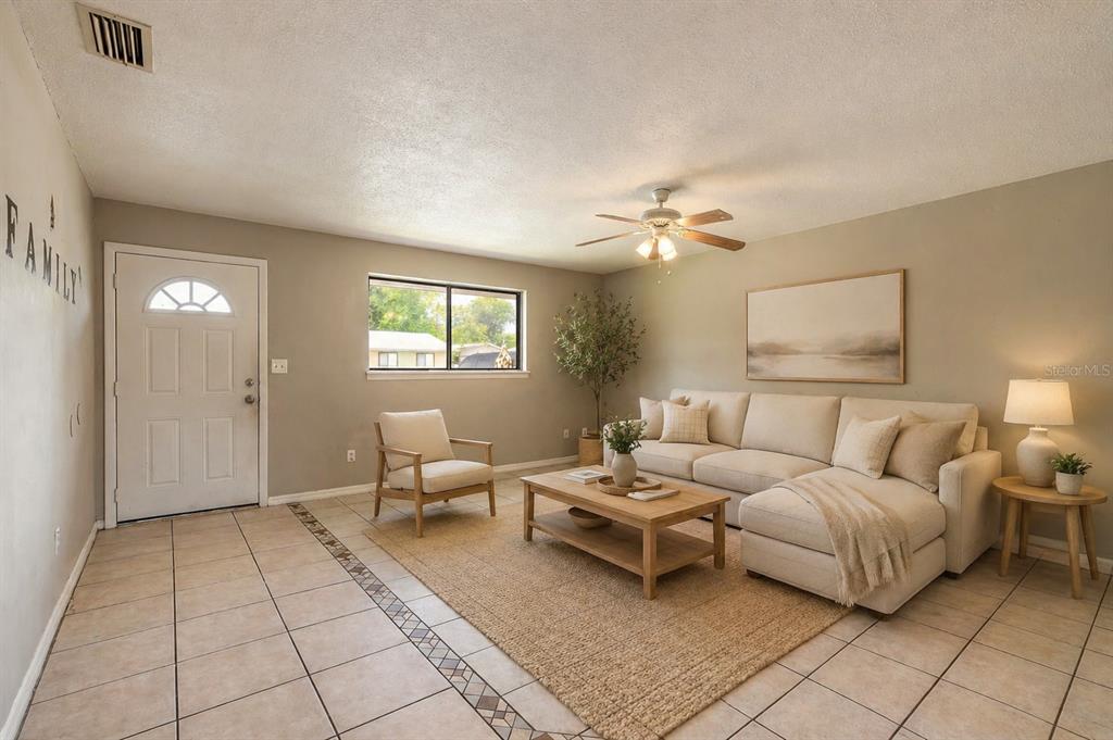 A living room features tile flooring, a beige sectional sofa, a coffee table, and a rug — 632 LPGA BOULEVARD UNIT B, DAYTONA BEACH, FL