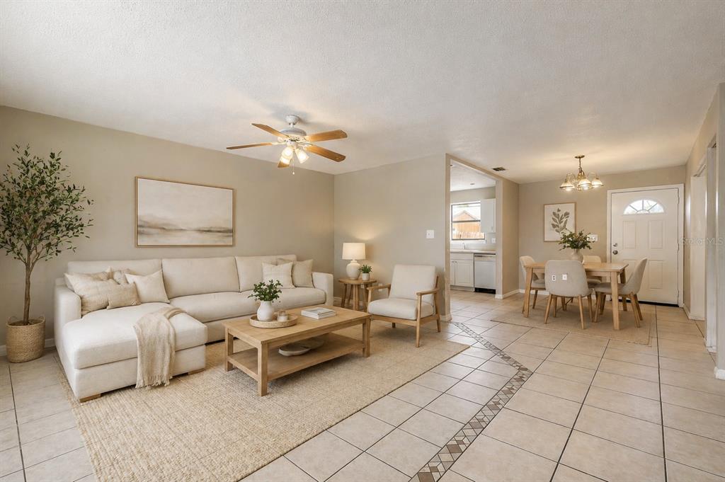 A living room and dining area with tile floors, a sectional sofa, and neutral decor — 632 LPGA BOULEVARD UNIT B, DAYTONA BEACH, FL