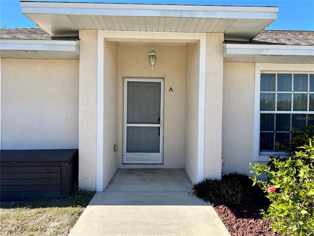 The exterior view shows a beige house entrance with a screen door marked A — 6795 DAVID BOULEVARD UNIT A, PORT CHARLOTTE, FL