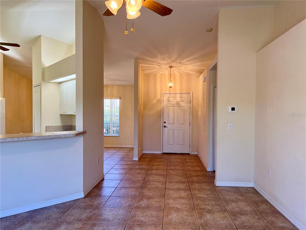 An interior view shows a tiled entryway leading to a front door and kitchen area — 6795 DAVID BOULEVARD UNIT A, PORT CHARLOTTE, FL