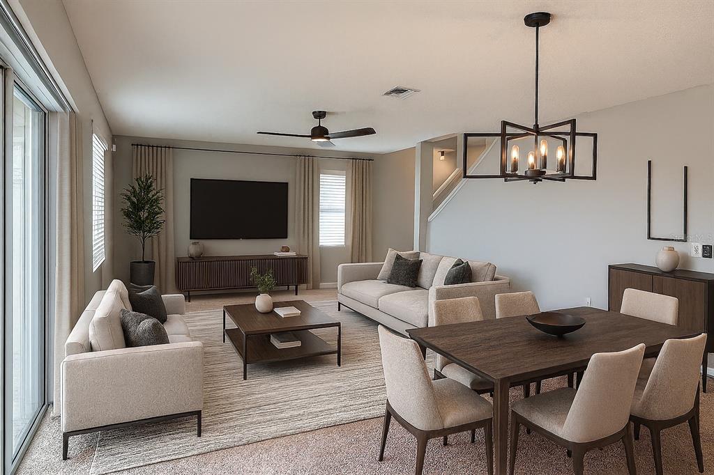 An open-concept living and dining area features neutral furniture, a dark wood table, and lighting — 362 NOVA DRIVE, DAVENPORT, FL