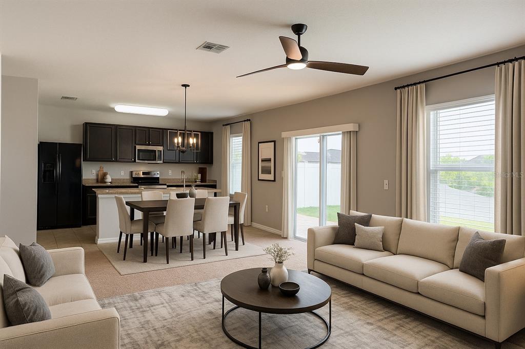 An open-concept living and dining area features a kitchen with dark cabinets and neutral furniture — 362 NOVA DRIVE, DAVENPORT, FL