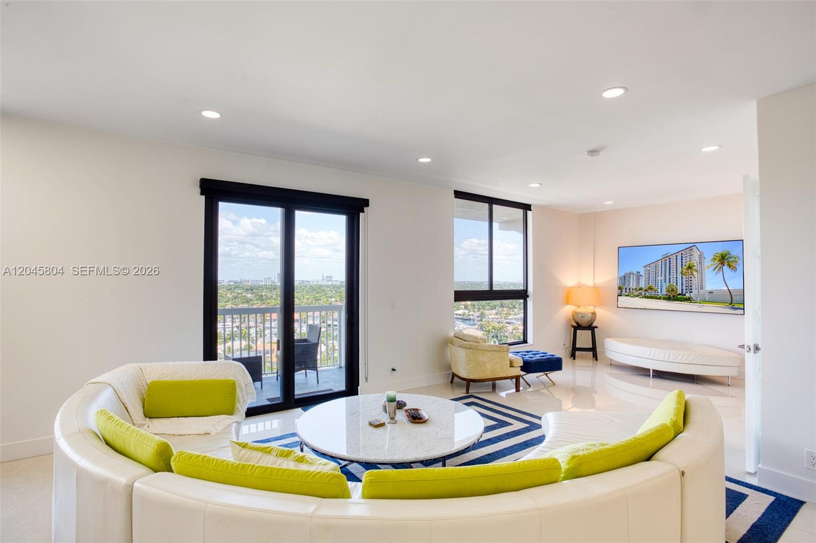 A living room features a curved white sofa, a marble coffee table, and balcony views — 1500 S Ocean Dr, Hollywood FL 33019, HOLLYWOOD, FL