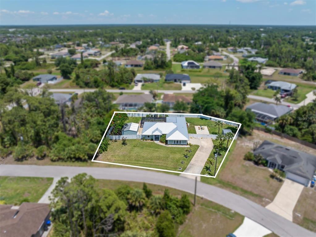 An aerial view shows a single-story house with a white fence and driveway — 1636 GLENAN ROAD, NORTH PORT, FL