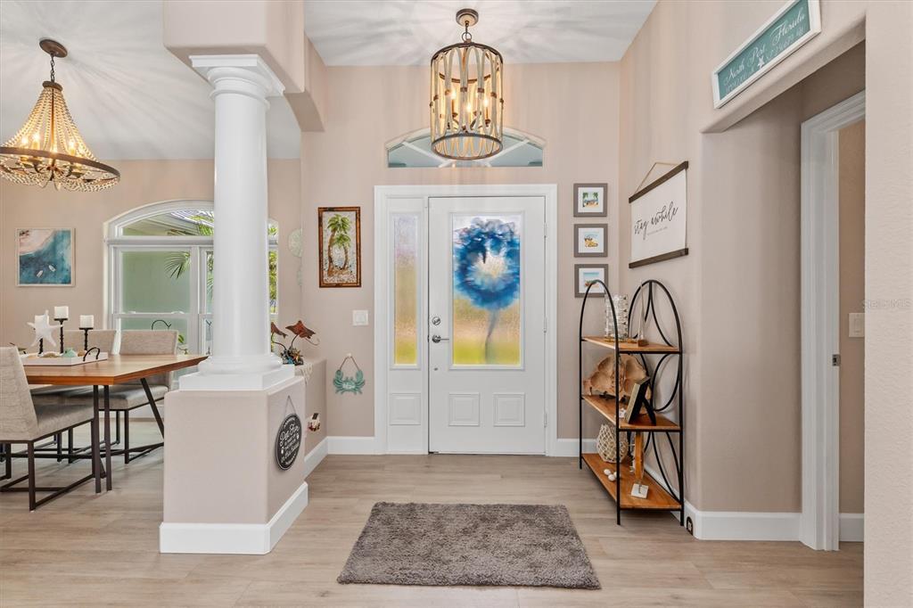 An entryway features a white front door with a floral glass insert and wood-look flooring — 1636 GLENAN ROAD, NORTH PORT, FL