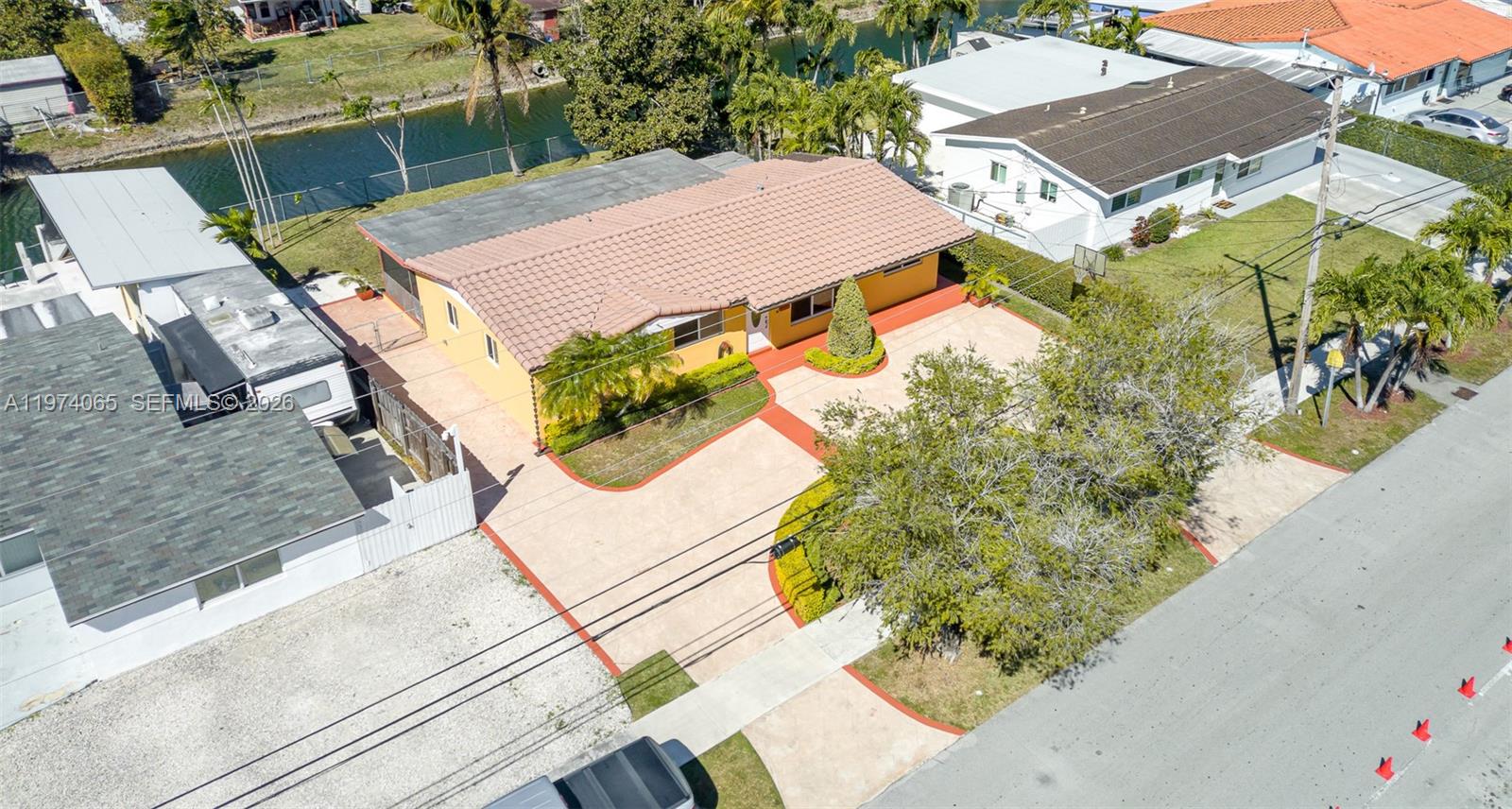An aerial view shows a yellow house with a tiled roof and a paved driveway — 4600 SW 104th Ave, Miami FL 33165, MIAMI, FL