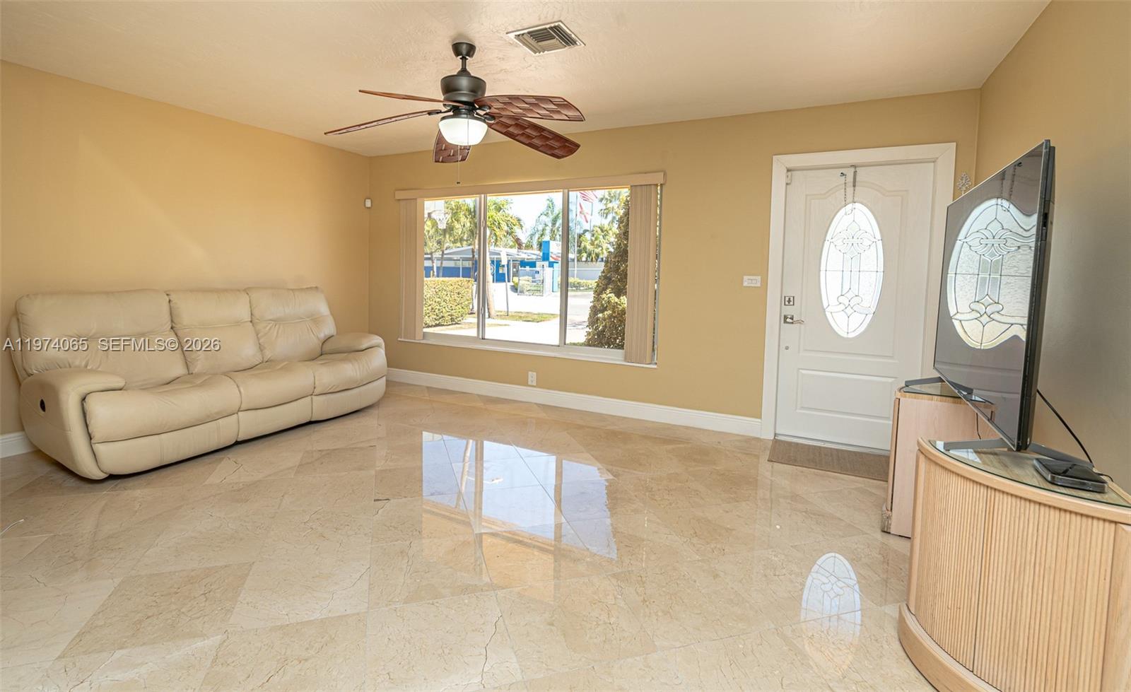 A living room features beige walls, a light-colored sofa, tile flooring, and a ceiling fan — 4600 SW 104th Ave, Miami FL 33165, MIAMI, FL