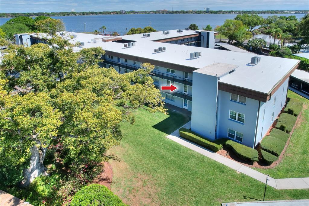 An aerial view of a multi-story apartment building with a red arrow pointing toward balconies — 333 LAKE HOWARD DRIVE NW UNIT 203C, WINTER HAVEN, FL