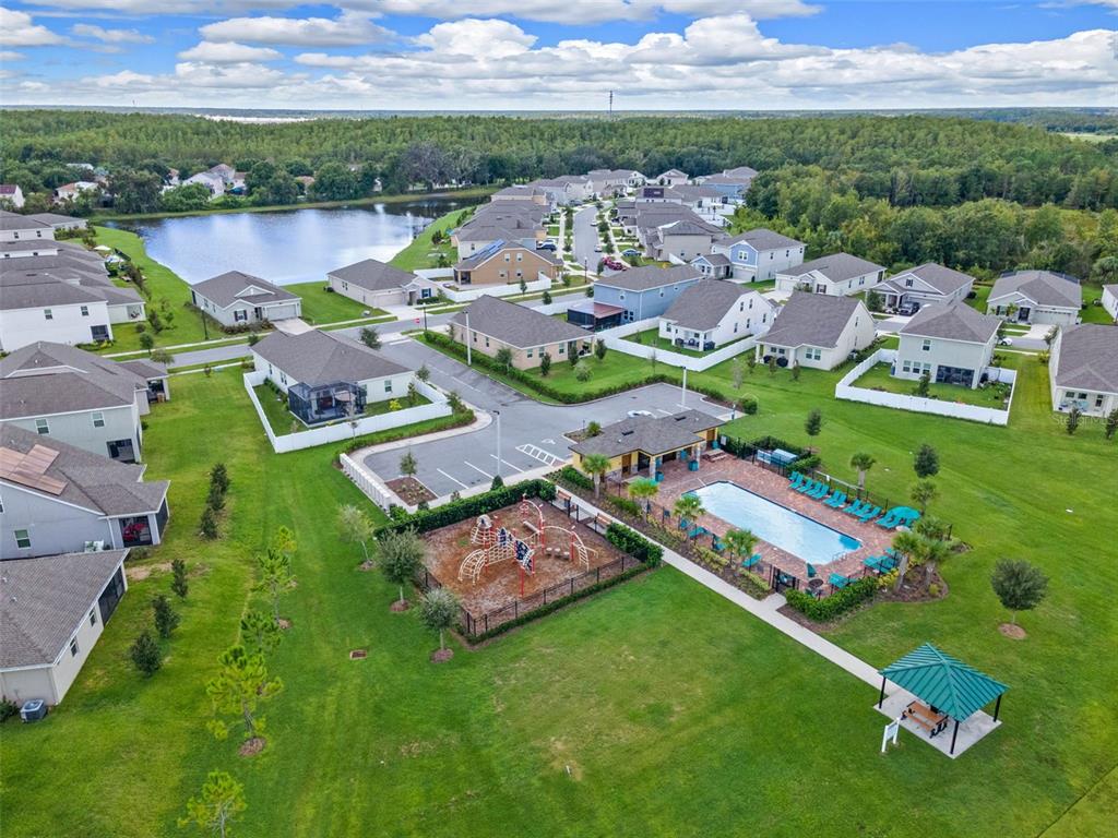 An aerial view shows a residential neighborhood with a community pool, playground, and gazebo — 2369 CRESCENT MOON STREET, KISSIMMEE, FL