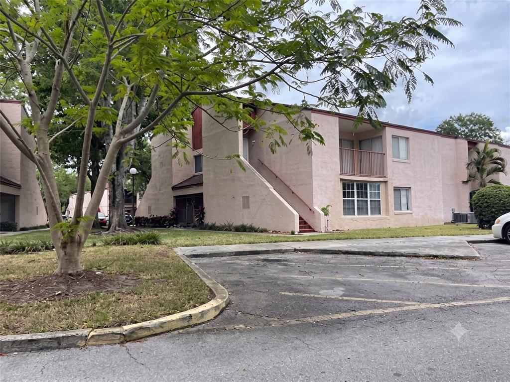 A two-story tan apartment building with an exterior staircase and a paved parking lot — 4322 LAKEWAY DRIVE UNIT 13F, ORLANDO, FL