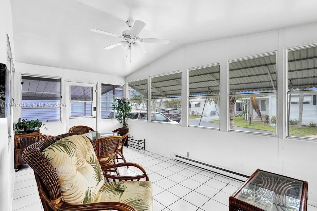 A sunroom with white walls, tiled floors, a ceiling fan, and large windows — 3495 Tee Terrace, Pompano Beach FL 33069, POMPANO BEACH, FL