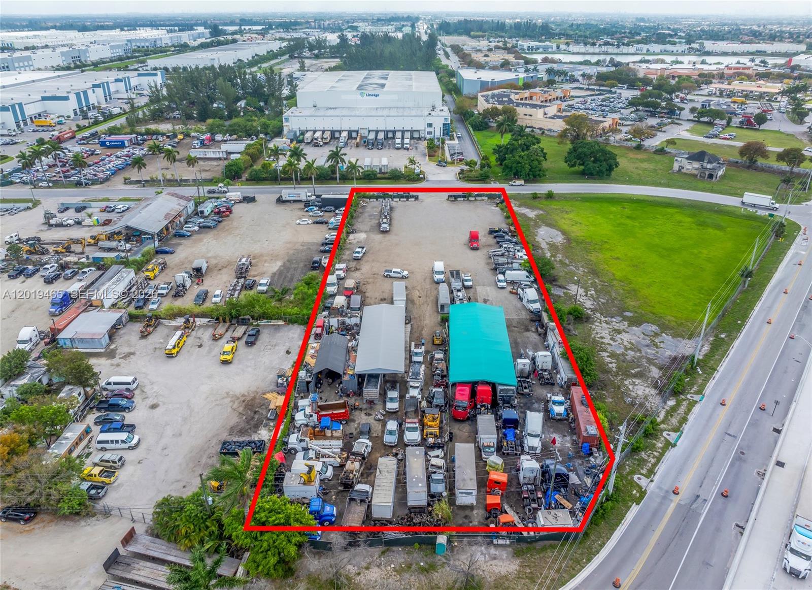 An aerial view shows a fenced industrial lot containing multiple trucks, trailers, and storage structures — 13800 NW 112th Ave, Hialeah Gardens FL 33018, HIALEAH GARDENS, FL