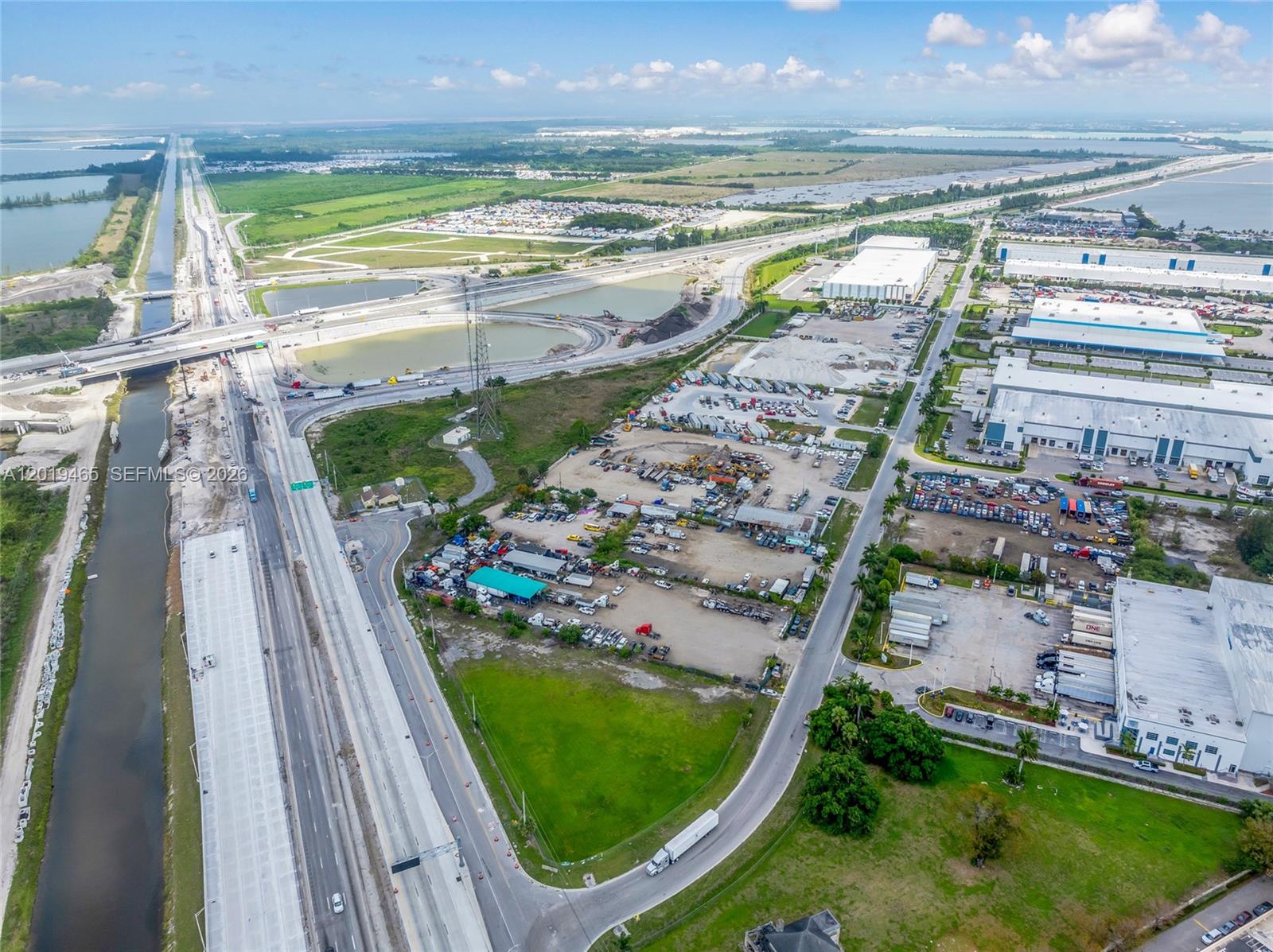 An aerial view shows a highway, a canal, and industrial warehouses with parking lots — 13800 NW 112th Ave, Hialeah Gardens FL 33018, HIALEAH GARDENS, FL