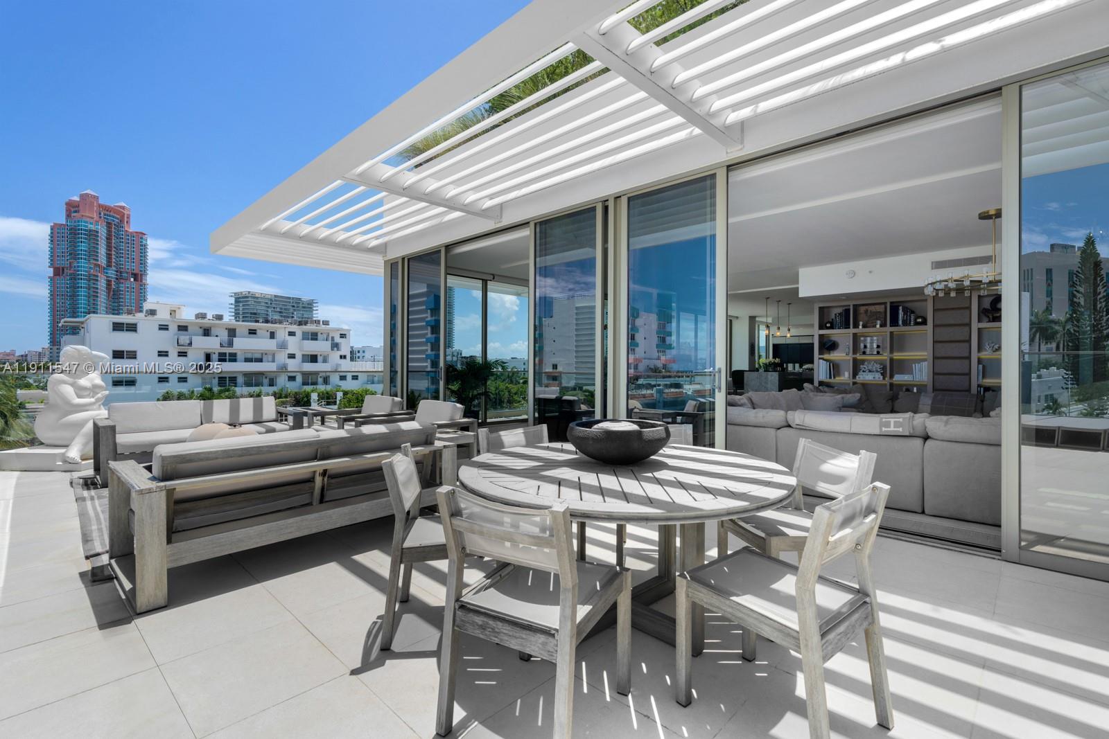 A modern outdoor terrace features a dining set, lounge furniture, and a white pergola — 300 Collins Ave, Miami Beach FL 33139, MIAMI BEACH, FL