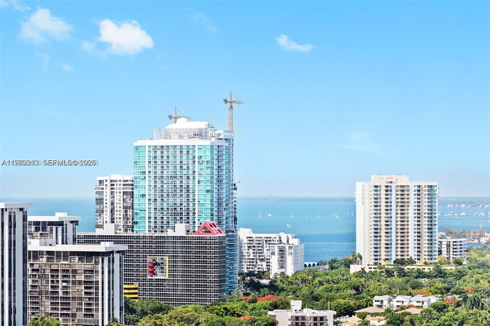An elevated view shows several high-rise apartment buildings overlooking a bay with sailboats — 1300 S Miami Ave # 2308, Miami FL 33130, MIAMI, FL