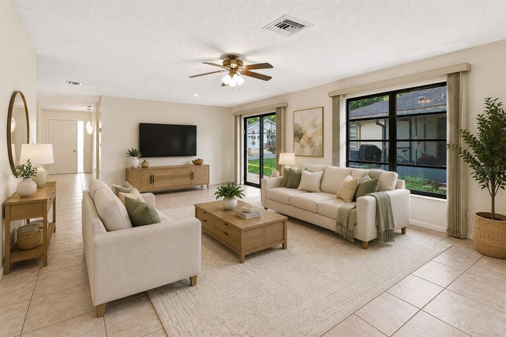 A living room features light tile floors, a beige sofa, a coffee table, and large windows — 83 GOLFVIEW DRIVE, HOMOSASSA, FL