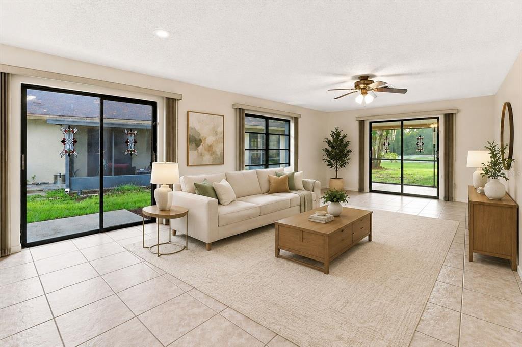 A living room with a beige sofa, wooden coffee table, tile floors, and sliding glass doors — 83 GOLFVIEW DRIVE, HOMOSASSA, FL