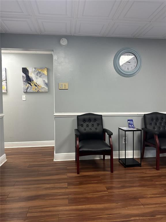 A waiting room features wood-look flooring, two black chairs, a wall clock, and a glass door — 318 N JOHN YOUNG PARKWAY UNIT 101, KISSIMMEE, FL