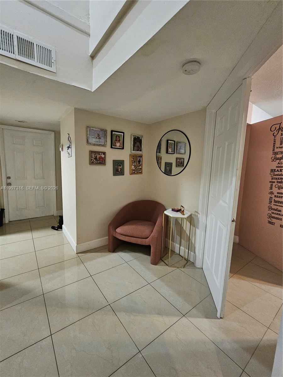 A corner nook features a pink armchair, a small side table, and a gallery wall — 13063 SW 88th Ter S # B, Miami FL 33186, MIAMI, FL