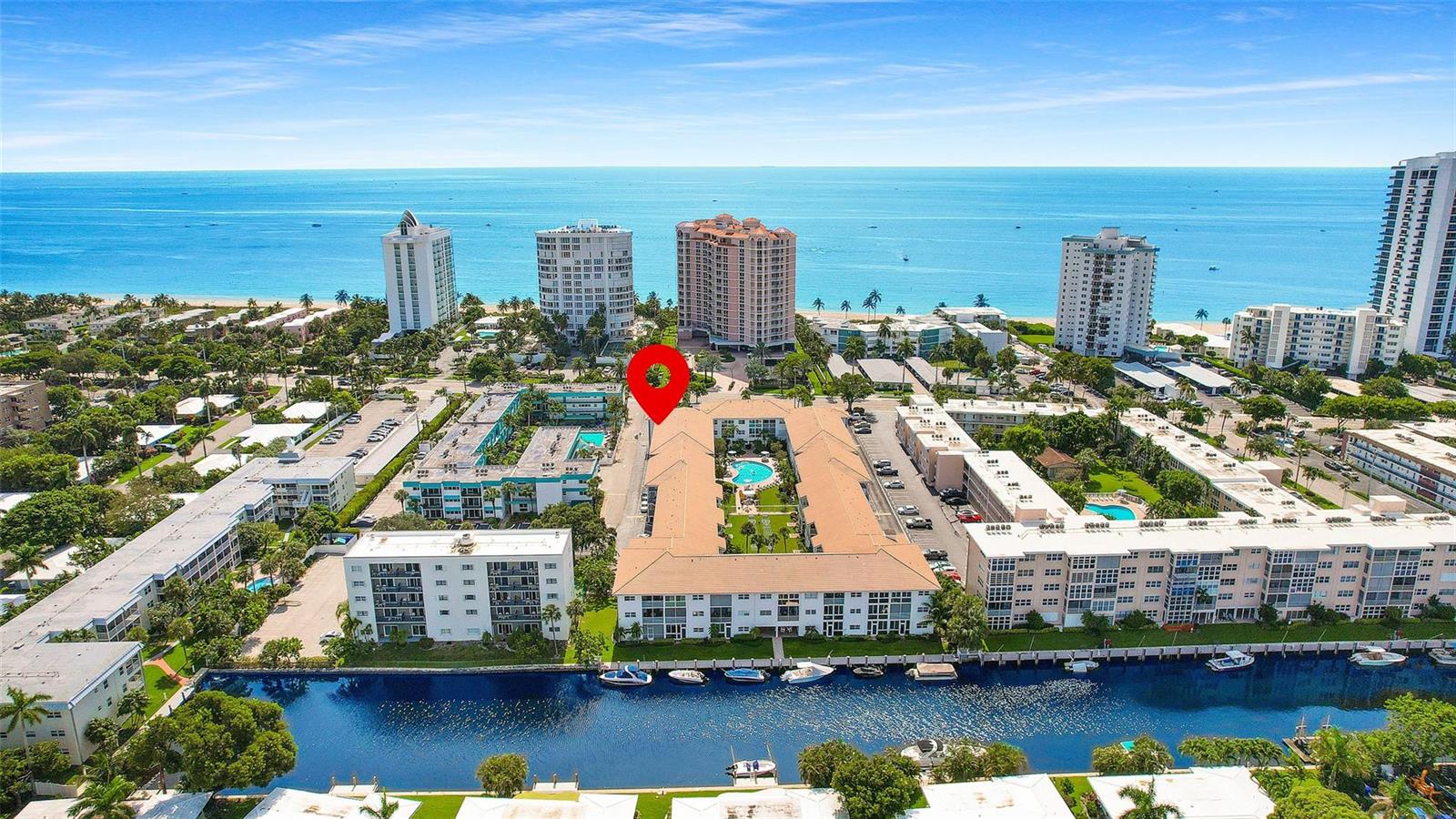 An aerial view shows a multi-story apartment complex with a central courtyard and swimming pool — 1461 S Ocean Boulevard # 329, Pompano Beach FL 33062, POMPANO BEACH, FL