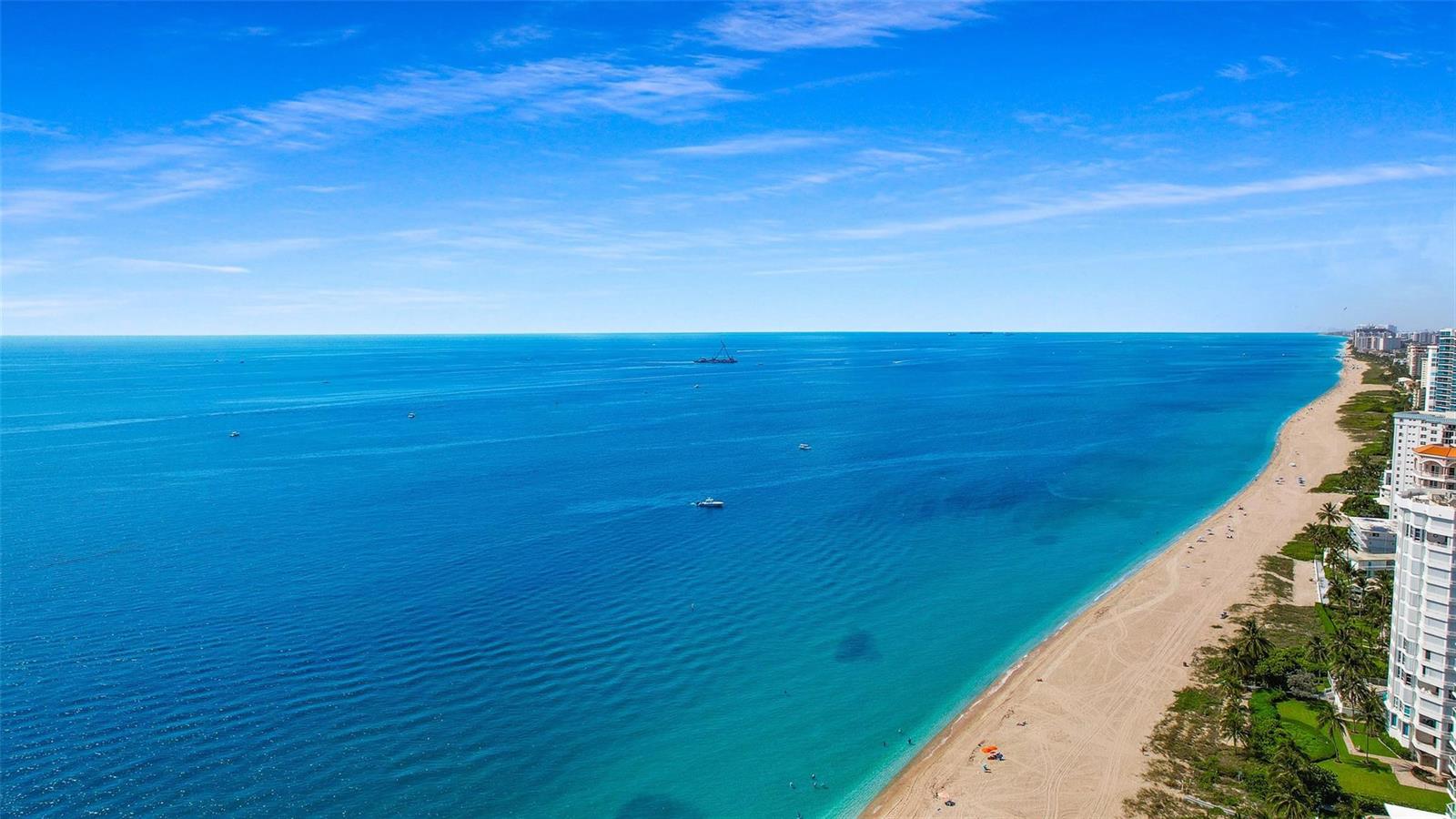 An aerial view of a sandy beach coastline meeting the blue ocean under a clear sky — 1461 S Ocean Boulevard # 329, Pompano Beach FL 33062, POMPANO BEACH, FL