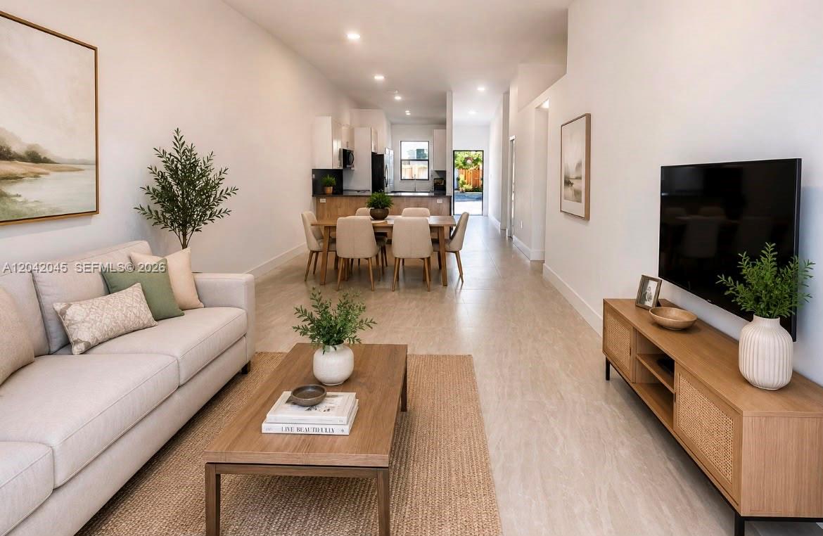 An open-concept living and dining area features light tile floors, neutral furniture, and a kitchen — 6780 NW 186th Ter, Hialeah FL 33015, HIALEAH, FL