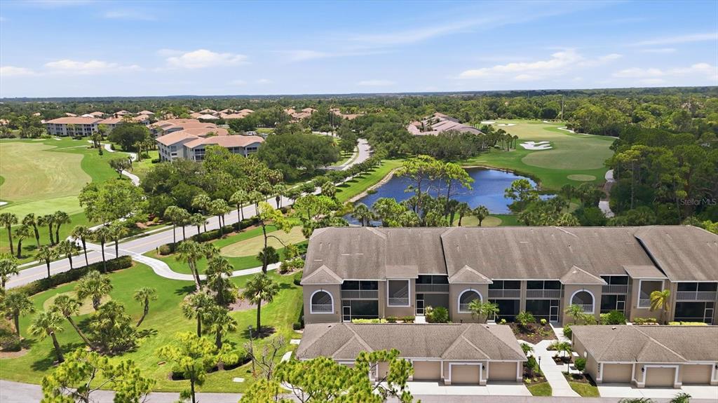 An aerial view shows multi-story residential buildings, a pond, and a golf course — 9540 HIGH GATE DRIVE UNIT 1411, SARASOTA, FL