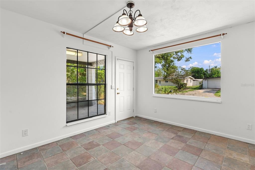 A room with white walls, tile flooring, a central light fixture, and two large windows — 1432 RICHMOND AVENUE, DAYTONA BEACH, FL