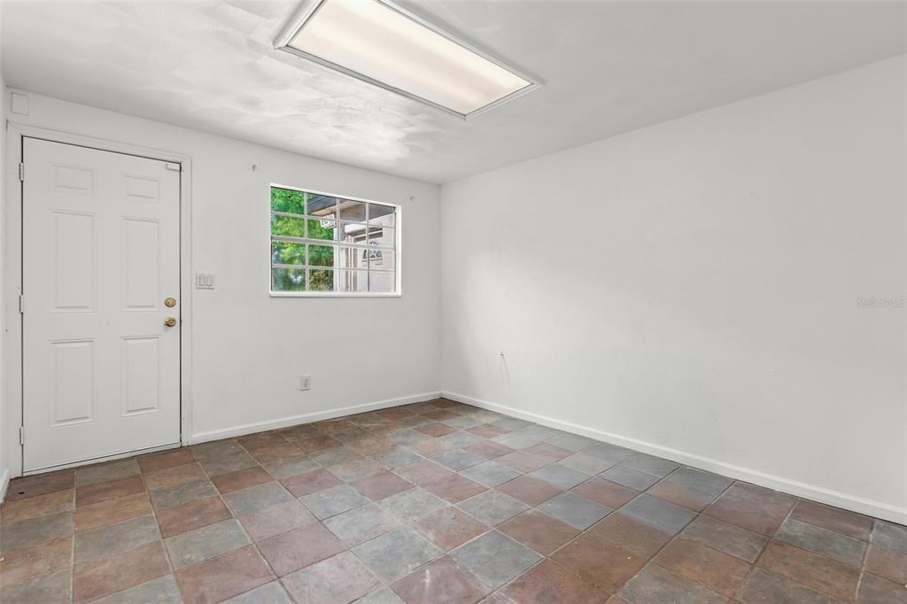 A room with white walls, a tiled floor, a single window, and a white door — 1432 RICHMOND AVENUE, DAYTONA BEACH, FL