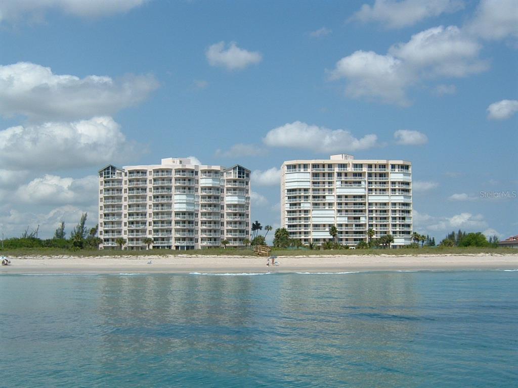 Two multi-story residential buildings stand behind a sandy beach along the ocean — 3880 N HIGHWAY A1A UNIT 104, HUTCHINSON ISLAND, FL