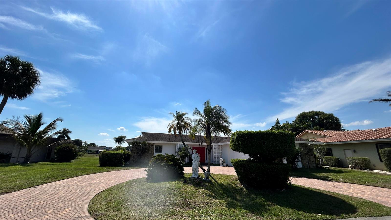 A single-story house with a brick driveway, palm trees, and a statue in the yard — 5728 S Bayberry Lane, Tamarac FL 33319, TAMARAC, FL