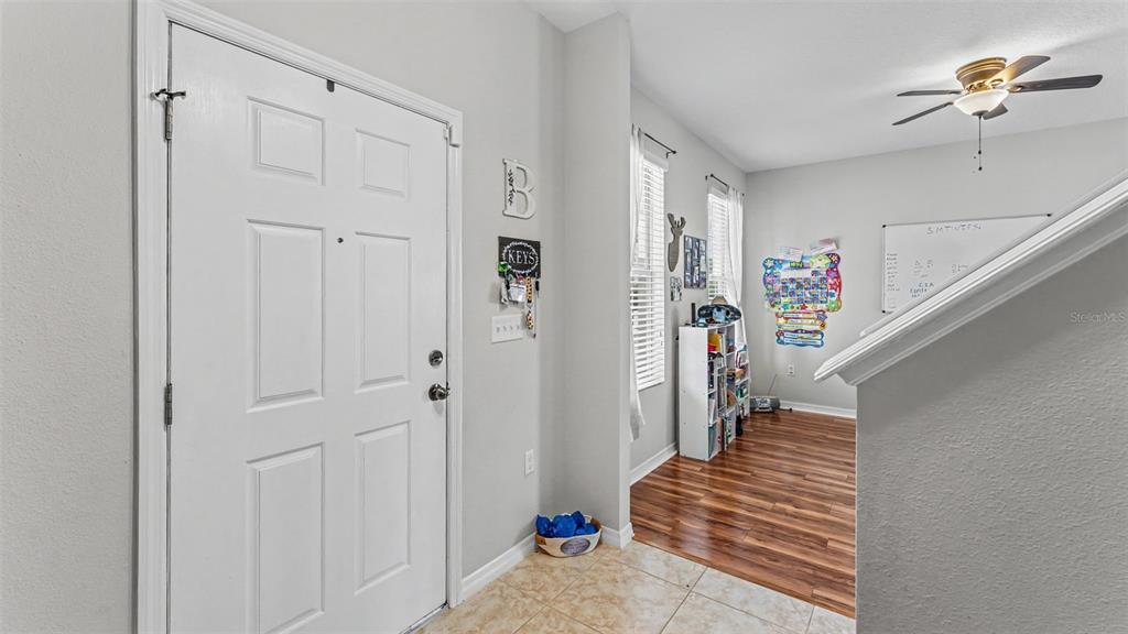 An entryway with a white door, tile flooring, and a view into a carpeted room — 2746 WALDEN WOODS DRIVE, PLANT CITY, FL