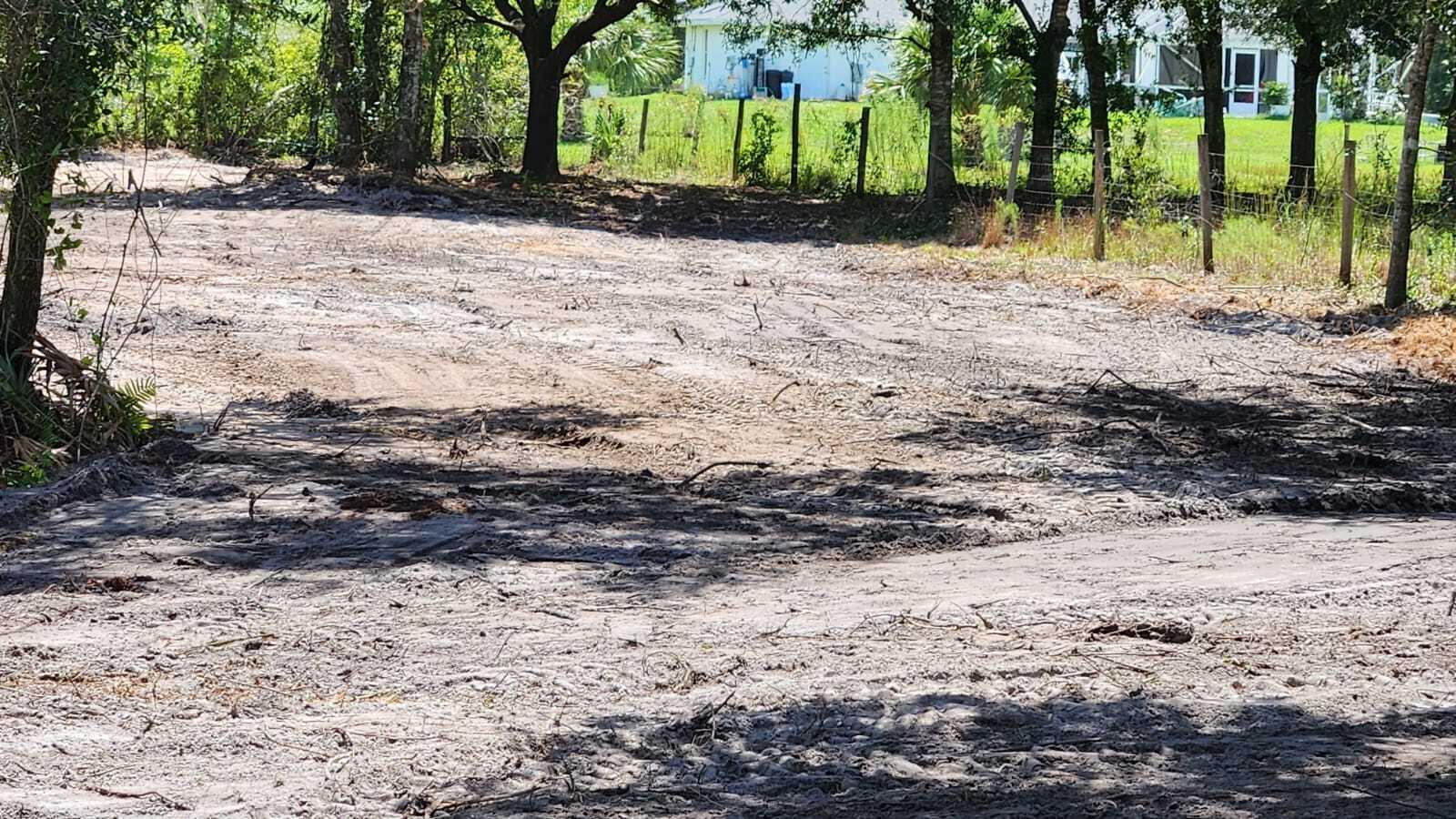 A cleared, sandy lot with scattered debris and trees bordering a wire fence — 18884 NW 282nd Street, Okeechobee FL 34972, OKEECHOBEE, FL