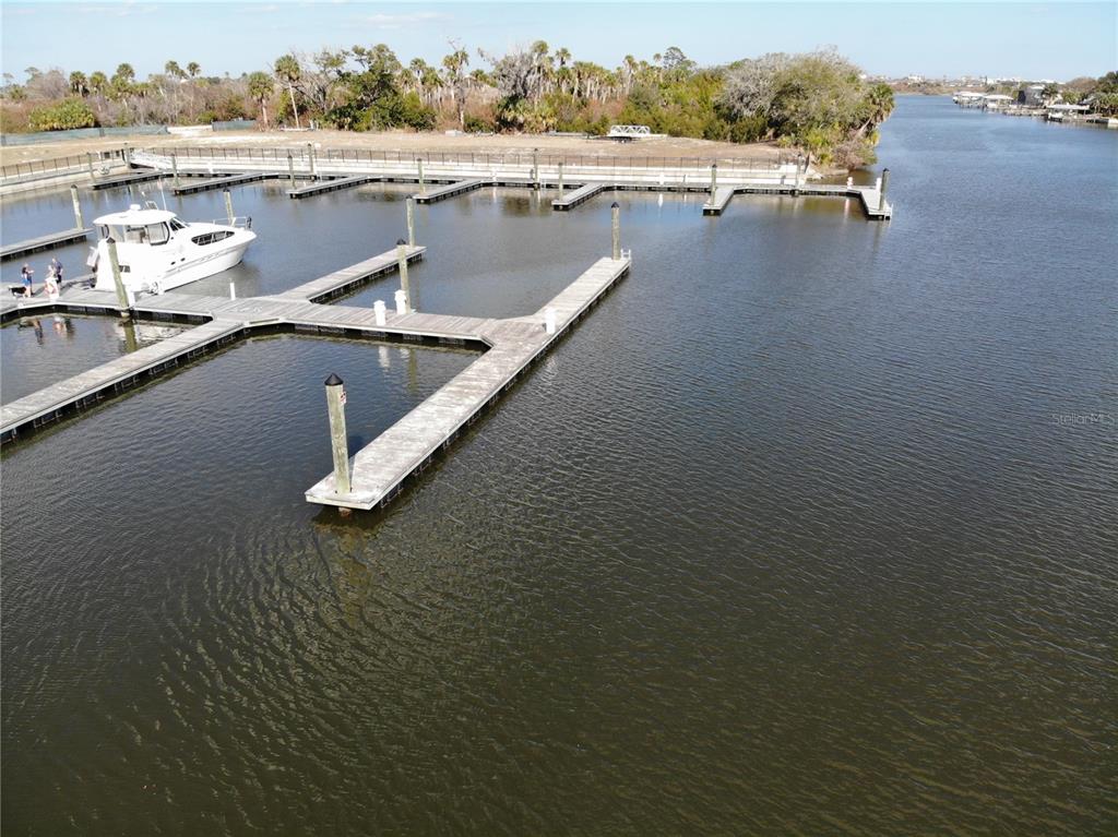 An aerial view shows a wooden boat dock with multiple slips and one docked yacht — 1 MARINA DEL PALMA UNIT B21, PALM COAST, FL