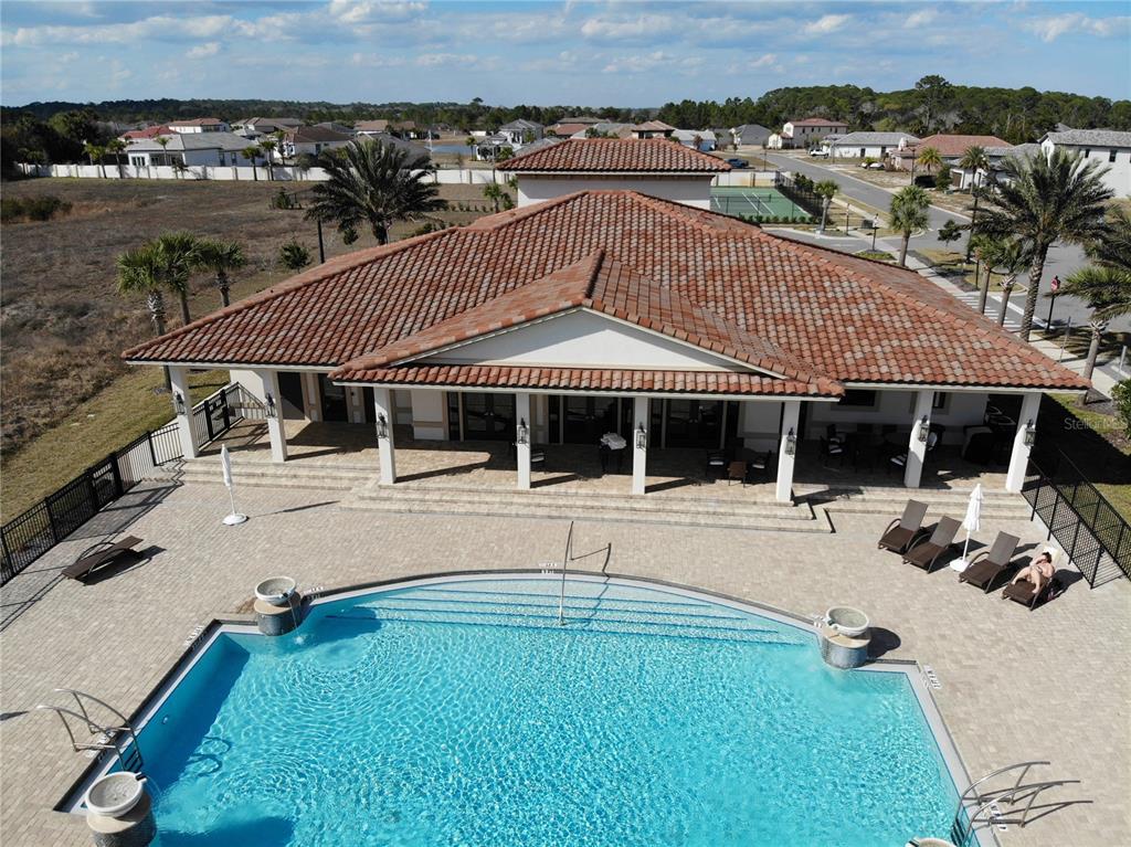 An aerial view of a community clubhouse featuring a tiled roof and a swimming pool — 1 MARINA DEL PALMA UNIT B21, PALM COAST, FL