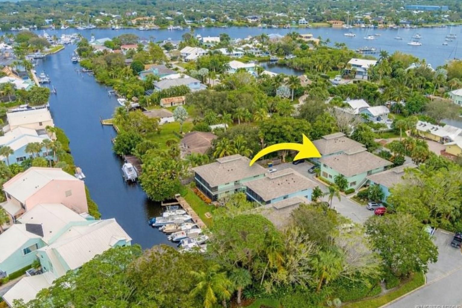 An aerial view shows multi-unit residential buildings with boat docks along a canal — 4099 SE Centerboard Lane # 4B, Stuart FL 34997, STUART, FL