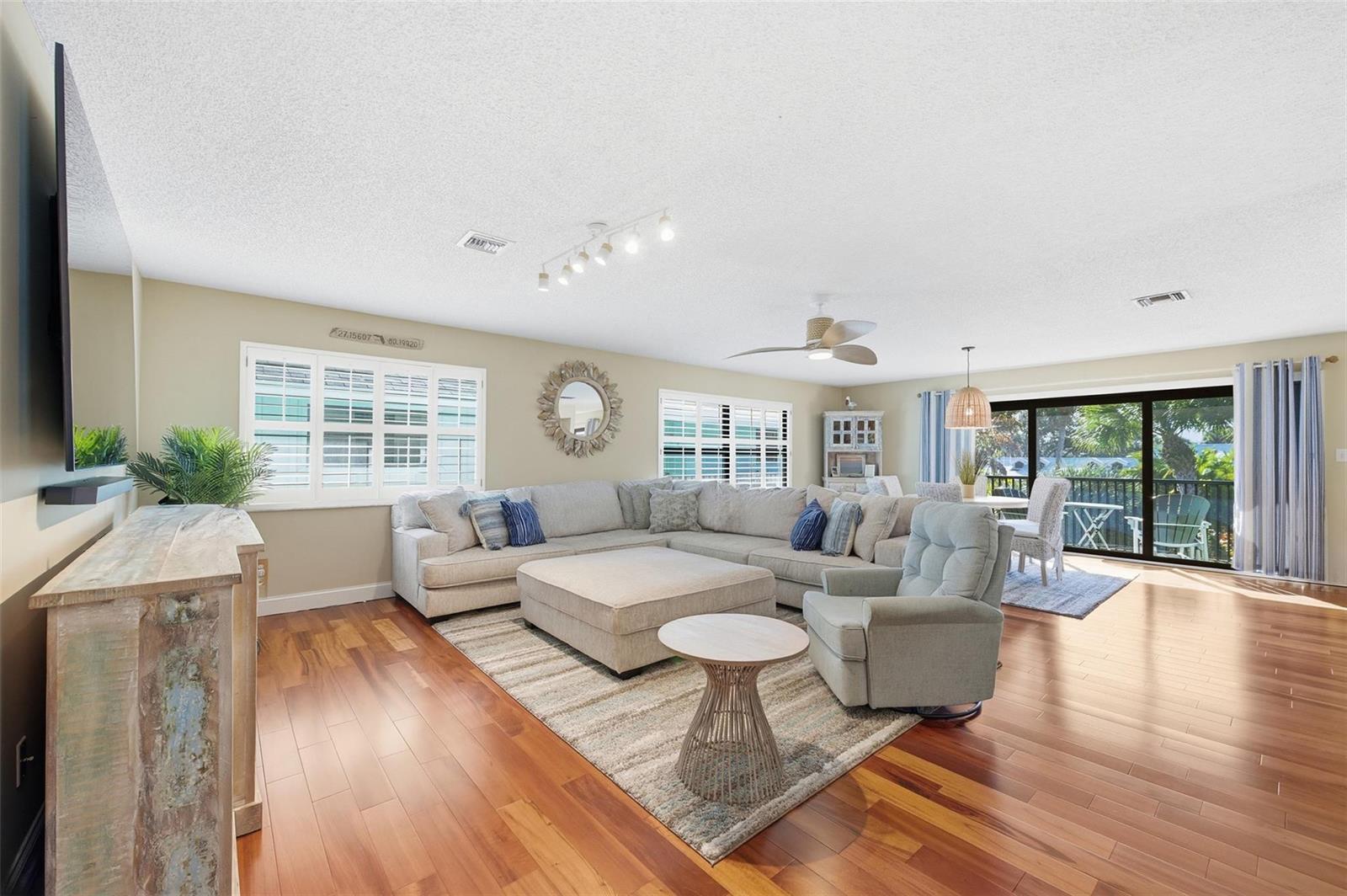 A living room features a large sectional sofa, a recliner, and hardwood floors — 4099 SE Centerboard Lane # 4B, Stuart FL 34997, STUART, FL