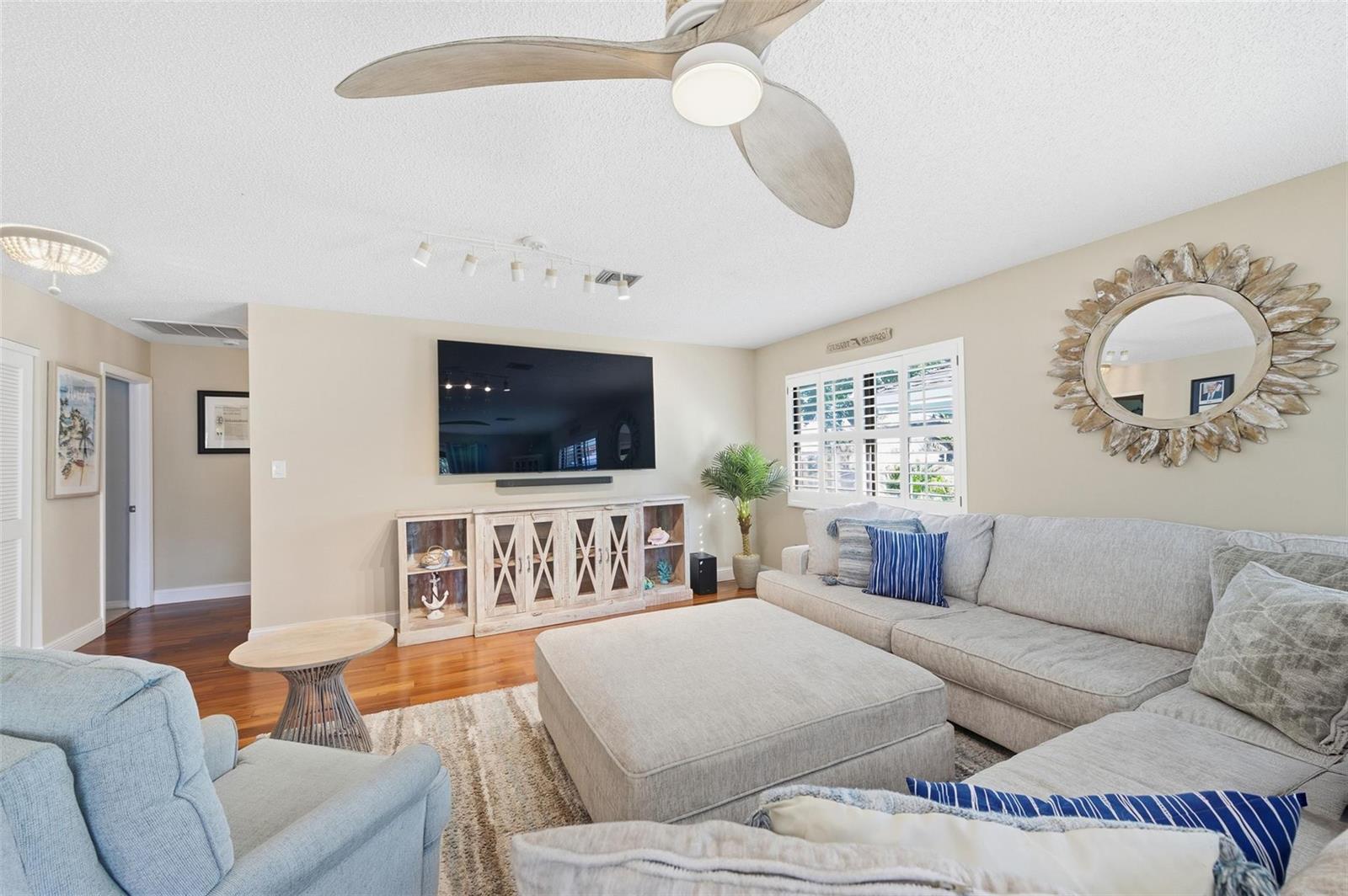 A living room features a large sectional sofa, a central ottoman, and a ceiling fan — 4099 SE Centerboard Lane # 4B, Stuart FL 34997, STUART, FL