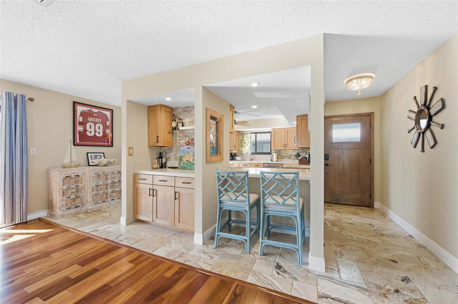 A kitchen with a bar area, light wood cabinets, and stone tile flooring — 4099 SE Centerboard Lane # 4B, Stuart FL 34997, STUART, FL