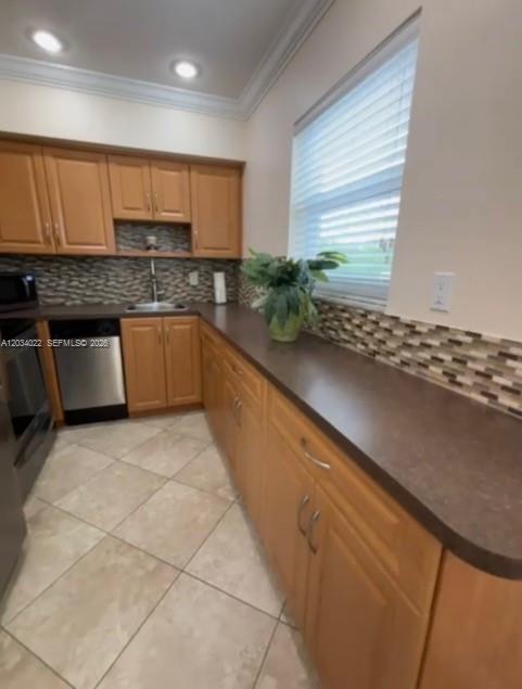 A kitchen with light wood cabinets, dark countertops, a tiled backsplash, and light floor tiles — 500 Layne Blvd # 20, Hallandale Beach FL 33009, HALLANDALE BEACH, FL