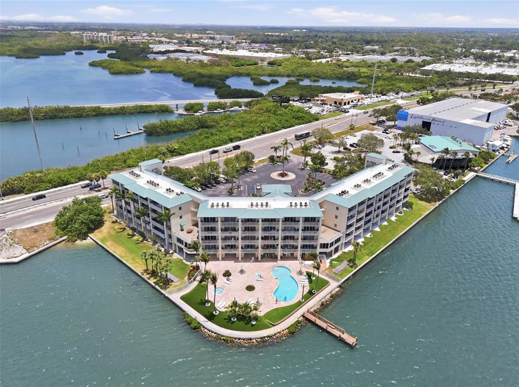 An aerial view of a waterfront condominium complex with a pool and a parking lot — 8800 BAY PINES BOULEVARD UNIT 216, ST PETERSBURG, FL
