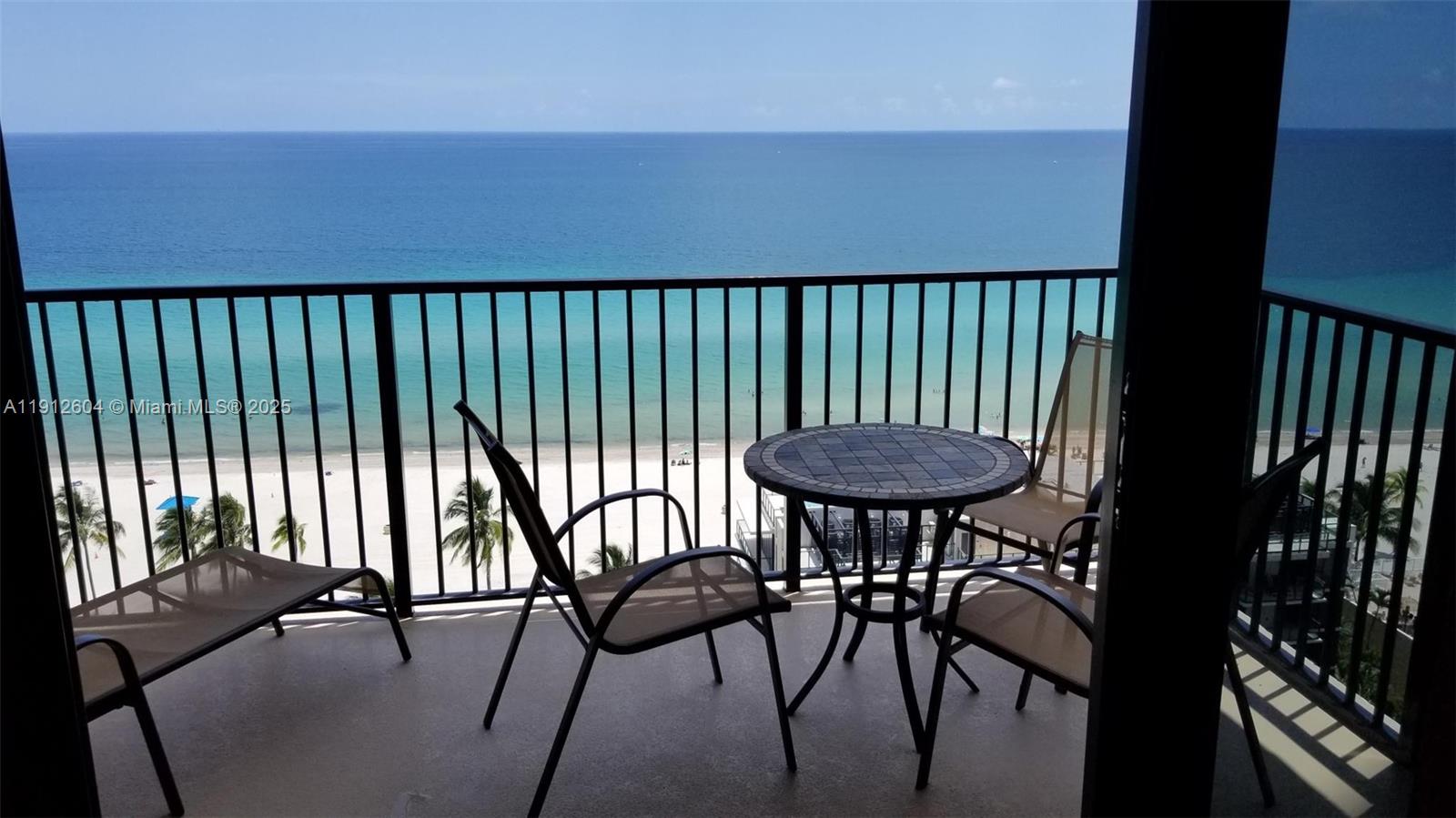 A balcony with patio furniture overlooks a sandy beach and the ocean — 2101 S Ocean Dr # 1702, Hollywood FL 33019, HOLLYWOOD, FL