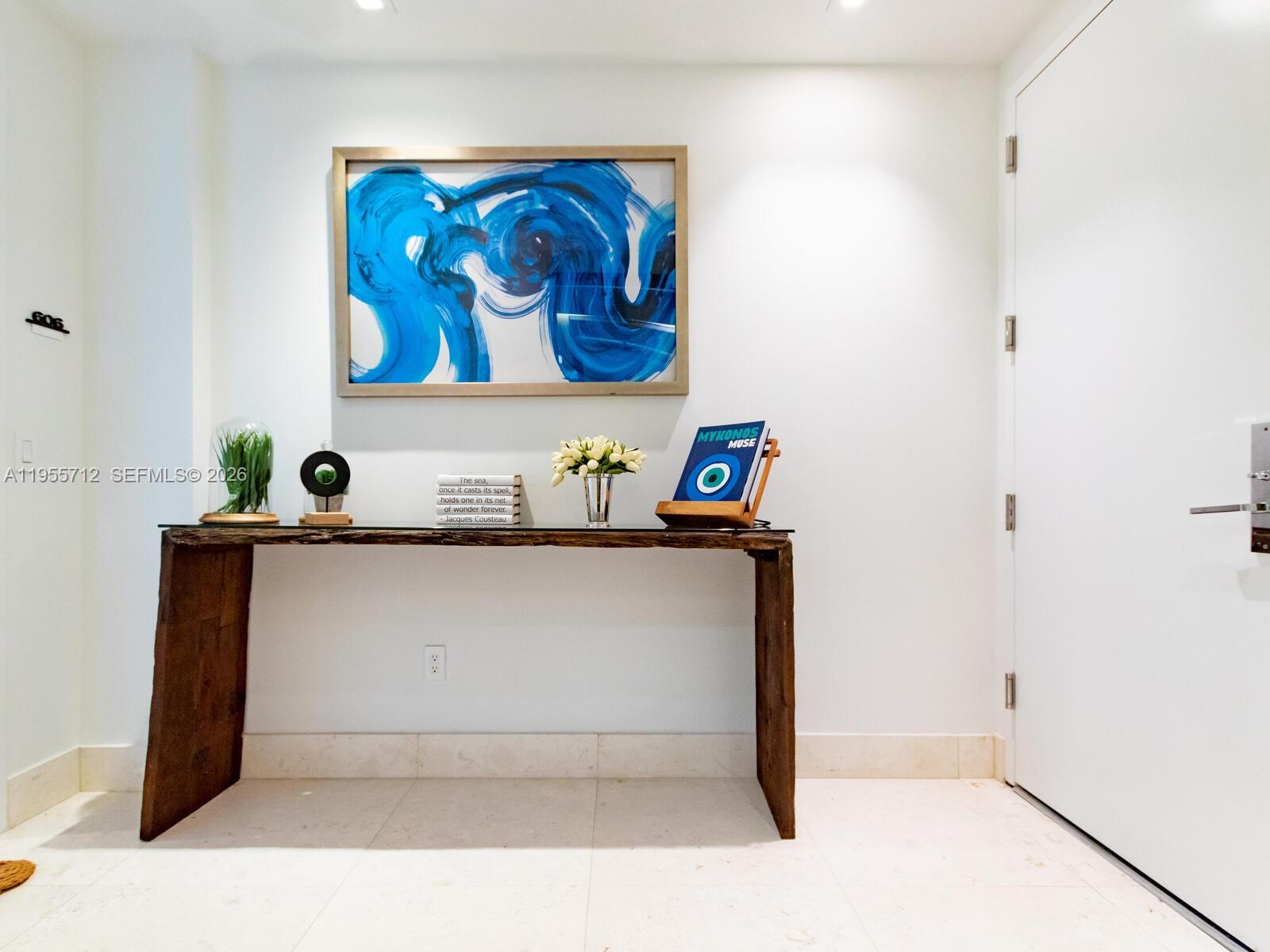 A console table with a live-edge top sits against a white wall beneath abstract art — 360 Ocean Dr # 606S, Key Biscayne FL 33149, KEY BISCAYNE, FL