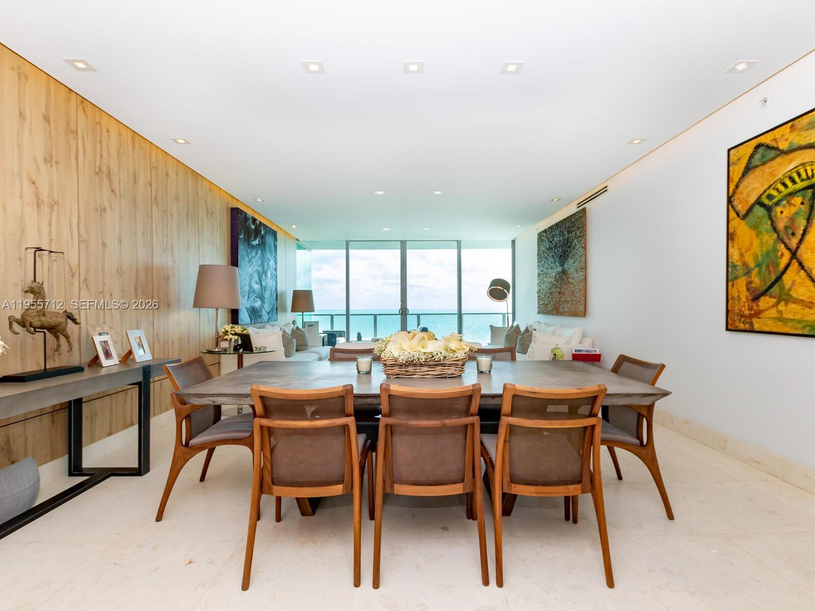A dining room features a large table, wooden chairs, and a view of the ocean — 360 Ocean Dr # 606S, Key Biscayne FL 33149, KEY BISCAYNE, FL