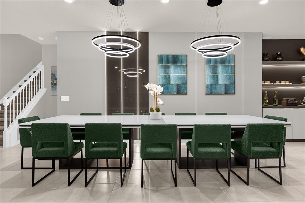A dining room features a long white table, green upholstered chairs, and modern ring chandeliers — 3048 MAHALO DRIVE, DAVENPORT, FL